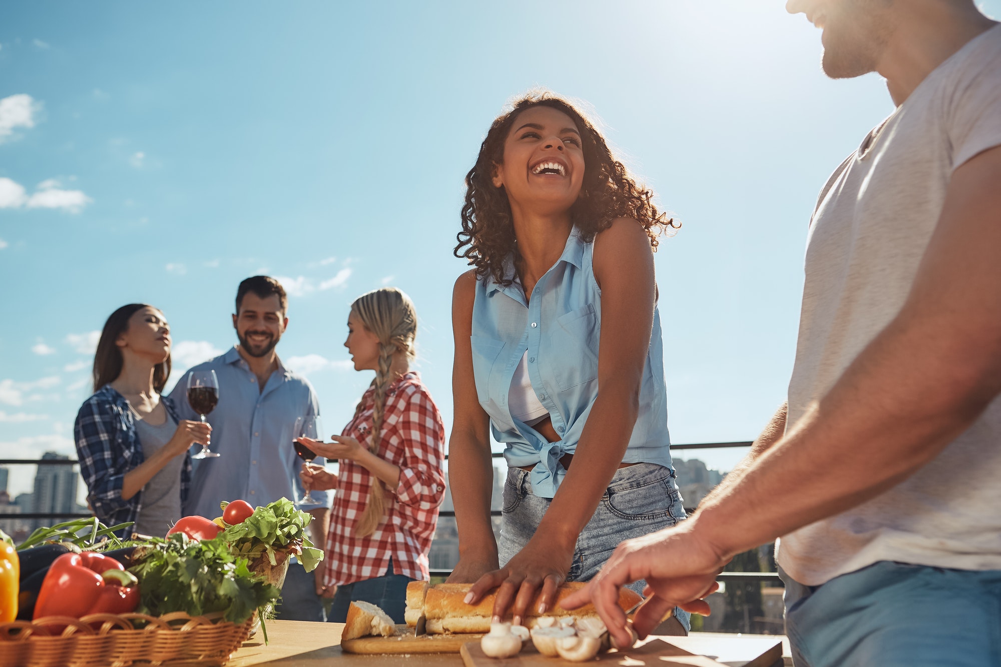 Summer picnic. Two young and cheerful friends in casual clothes preparing food for barbeque party
